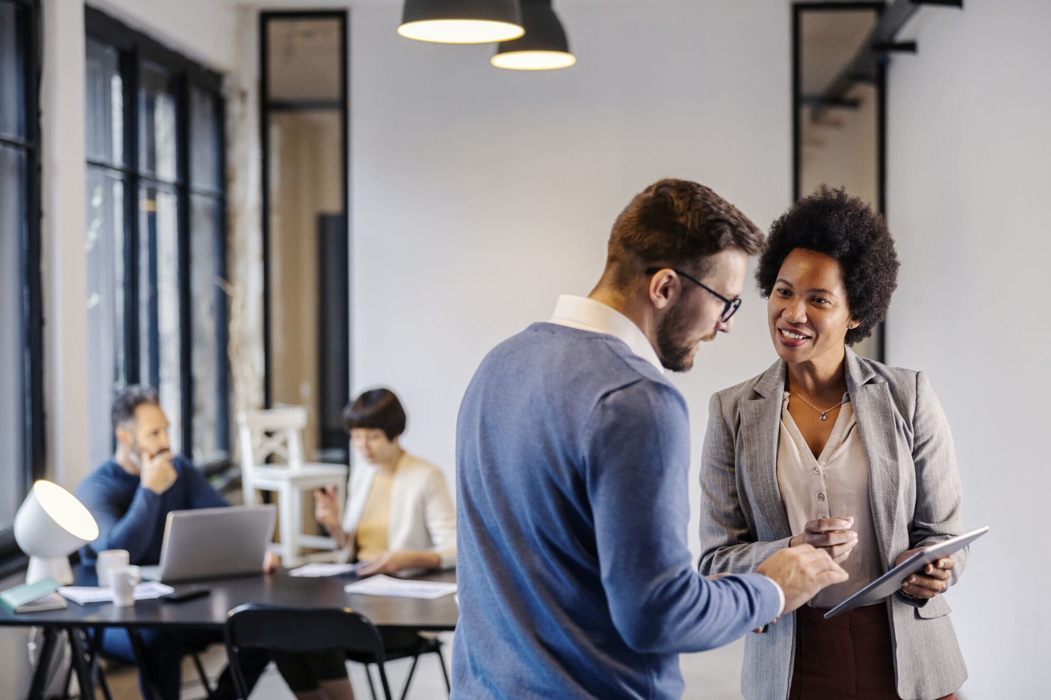Two colleagues discussing work in an office.