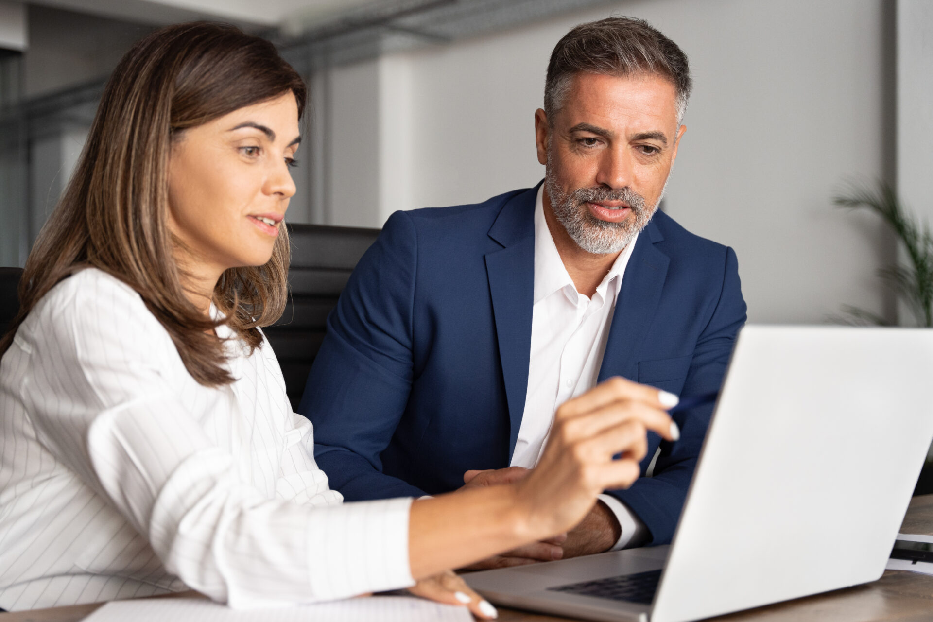 A man and woman looking at a laptop