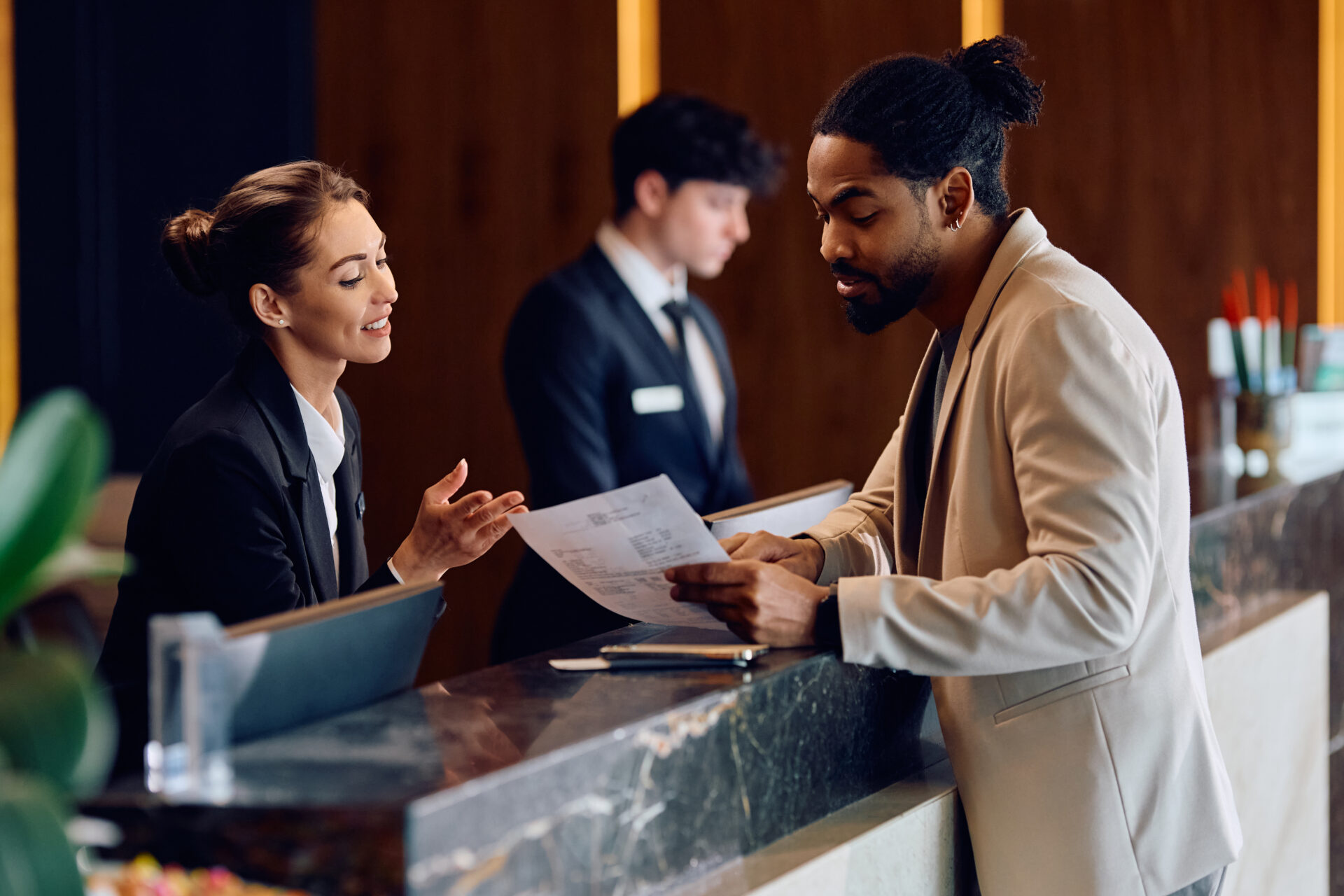 A man and woman standing at the front of a hotel lobby.