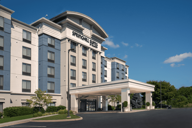 A large hotel with a parking lot in front of it.